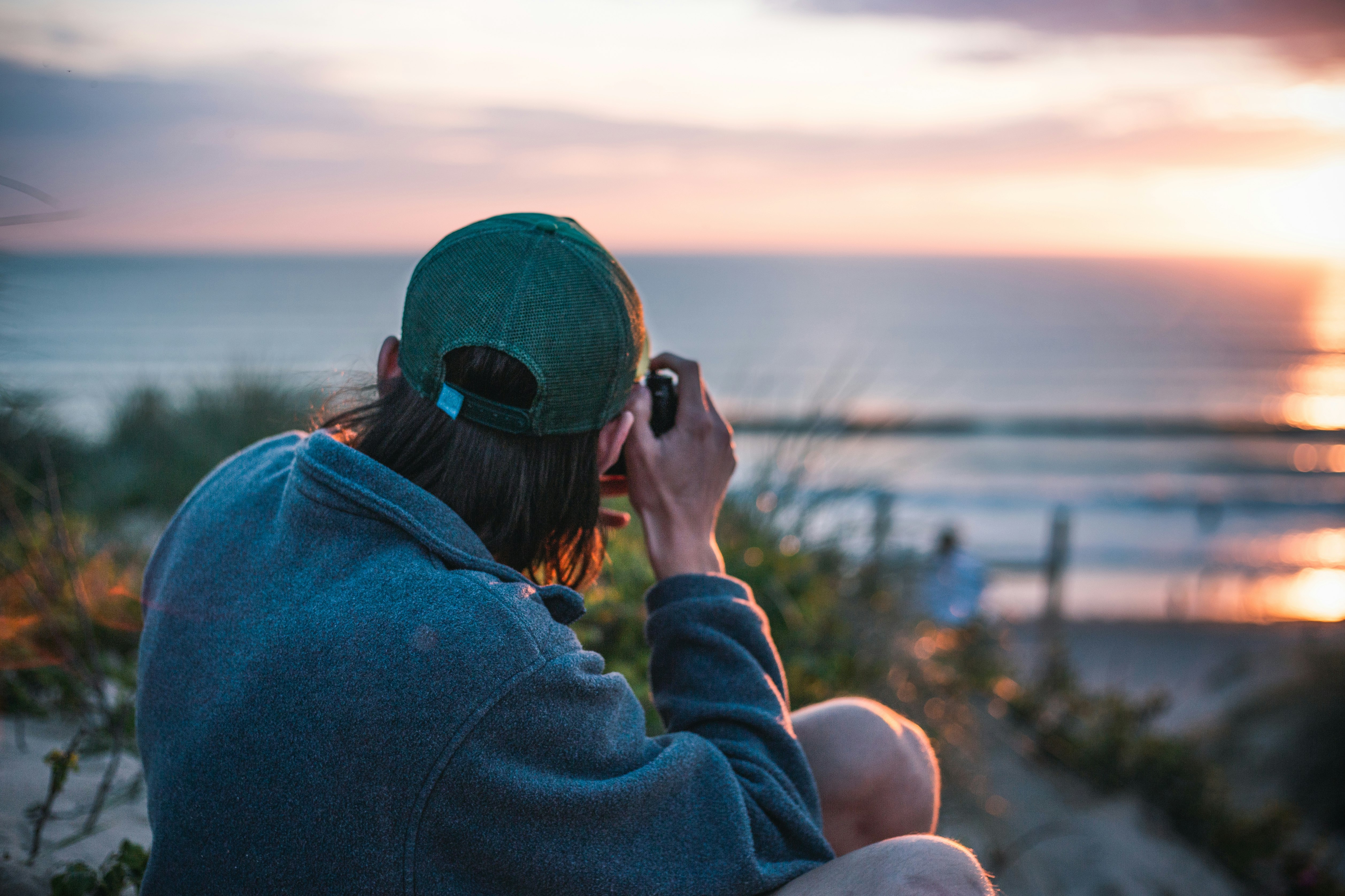 woman in blue hoodie wearing green cap